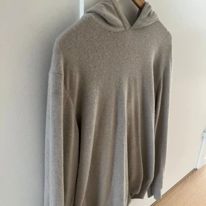 Beige hoodie i kashmir - Mjuk och lyxig beige hoodie i kashmir med lång ärm. Perfekt för en avslappnad och stilren look. Klassisk huva och enkel design utan synliga detaljer. 100% Kashmir från Oscar Jacobson