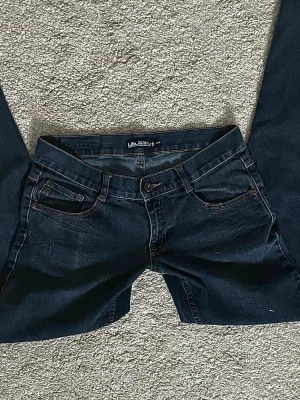 Lowwaist mörkblå jeans från Lab Industries - Säljer ett par mörkblå jeans från Lab Industries. Jeansen har normal passform och raka ben. Passsar S/ storlek .