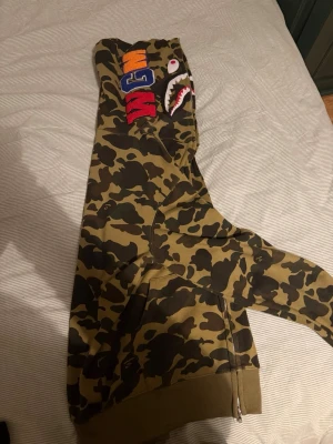Bape hoodie - Säljer nu en bape hoodie jag fick av en grabb för att jag klippte hans hår. Storleken säger 3XL men passar mig som har XL. Inga hål eller liknande och är i väldigt fint skick. Som sagt, har NOLL koll på bape och kan inte garantera om varan är äkta eller inte, hur som helst så är den fet (för rätt stil) och gjord i kvalitets material enligt mig. Vid frågor eller funderingar släng iväg ett PM så löser vi det. //mvh MB