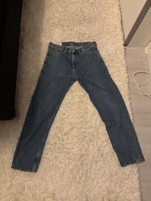 Relax fit blåa jeans H&M - Säljer ett par blå relaxed fit jeans från H&M i storlek 32/32. Klassisk femficksmodell med rak passform och normal midja. Jeansen är gjorda i tåligt denimtyg och har en enkel, tidlös look som passar till det mesta.