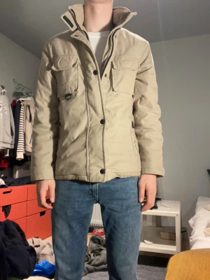 Field jacket Polbot - Made in Italy  - OBS!! DRAGKEDJAN HAR GÅTT SÖNDER LITE MEN FUNGERAR FORTFARANDE. Italiensk beige, vadderad , fieldjacket. Storlek S - M. Pyttelite för stor för mig (175 cm 60 kg). Men jättesnygg och väldigt bra kvalité. Grön beige aktig färg. 