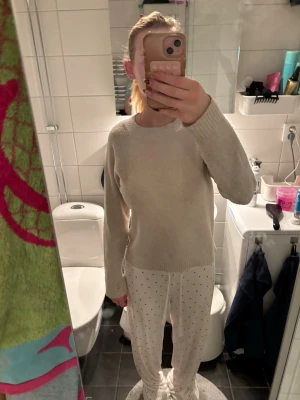 Beige stickad tröja i enkel design - Enkel och stilren beige stickad tröja med rund halsringning och ribbade muddar. Tröjanhar en rak passform och är gjord i ett mjukt material.