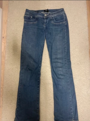 Blå bootcut jeans från LTB - Snygga blå jeans från LTB i modellen valerie med klassisk femficksdesign och bootcut-ben. Jeansen har dragkedja och knapp framtill samt detaljerade sömmar. Perfekta för dig som gillar en tidlös look med lite utsvängda ben. Materialet är jeans i bomull.