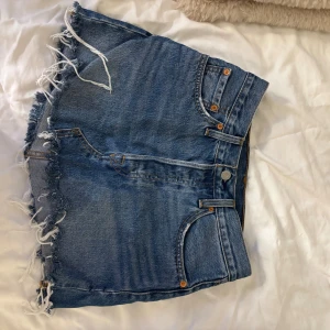 Levi's jeanskjol med fransig kant - Säljer en blå jeanskjol från Levi's med fransig kant nertill. Bra skick och super snygg💓 Passar mig som har Xs/s