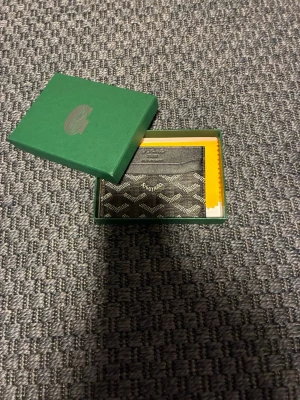 En svart plånbok - En svart plånbok med mönster. Man får med ett lyxigt Paris kort med.