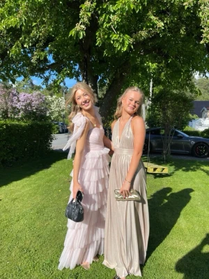 Ljusrosa  balklänning  - Superfin långklänning i ljusrosa med flera lager volanger och axelband med rosett. Endast använd en gång på min bal förra året. Skriv för fler bilder! Märket är lace and beads men den är köpt på asos. 