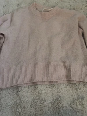 Ljusrosa stickad tröja Gina Tricot - Supermysig ljusrosa stickad tröja från Gina Tricot. Tröjan har rund halsringning, ribbade muddar och nederkant samt lång ärm. Perfekt för lager-på-lager under kyliga dagar.