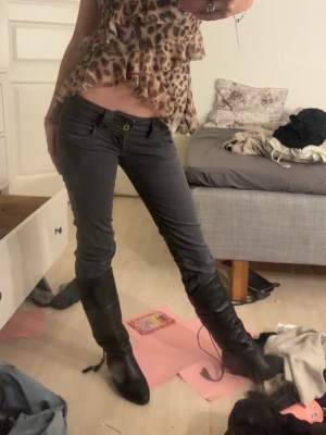 Mörkgrå slim jeansbyxor - Säljer ett par mörkgrå jeansbyxor med låg midja och slim passform som inte säljs längre. Köpte de för längesedan men har inte använt dom en enda gång. Byxorna har klassisk femficksdesign och stängs med knapp och dragkedja. Perfekta till boots och funkar till många olika stilar. 