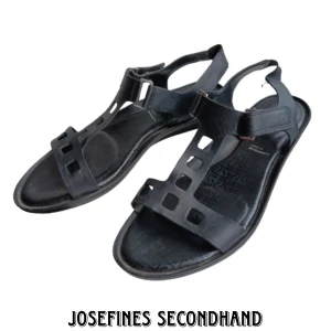 Svarta sandaler - Svarta sandaler från Rockport, köpta utomlands. Är av fejkläder ich har mönster på sulan. Är skadad på hälarna men är i övrigt i bra skick