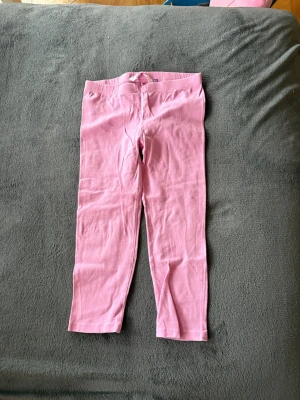 Rosa leggings i bomull stl 146/152 - Säljer ett par mjuka och stretchiga rosa leggings i storlek 146/152. De har en enkel design med resår i midjan och är perfekta för en avslappnad och bekväm stil. Materialet är bomull som känns skönt mot huden.