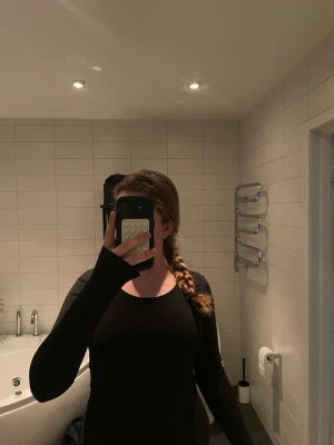 Svart långärmad topp från Basic You - En svart långärmad topp från Basic You i ekologisk bomull. Enkel och stilren design med rund halsringning och figurnära passform. Perfekt basplagg att ha i garderoben och funkar till många olika outfits. Storlek M.