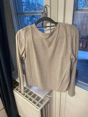 Beige kofta från KappAhl, storlek M - Snygg beige kofta från KappAhl i storlek M. Den har rund hals, långa ärmar och knappar framtill. Materialet känns mjukt och lätt, perfekt för lager-på-lager. Enkel och stilren design som funkar till många olika looks.