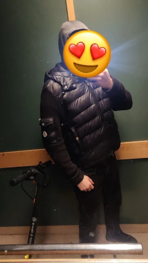 Svart dunväst från Moncler - Snygg svart dunväst från Moncler med glansig finish och quiltad design. Västen har dragkedja framtill och diskreta knappar. Perfekt för lager-på-lager och ger en clean streetstyle-look.