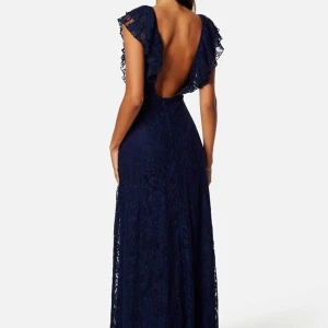 Marinblå spetsklänning med öppen rygg - Marinblå balklänning i spets med djup v-ringning och öppen rygg. Den är endast använd en kväll så den är som ny! Nypris ligger på cirka 1200kr. 