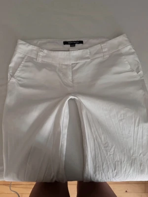 Vita bootcut byxor från Tally Weijl - Snygga vita bootcut-byxor från Tally Weijl med låg midja och breda benslut. Perfekt för dig som gillar en clean och trendig look. Säljer vidare då de inte passade mig! ♡