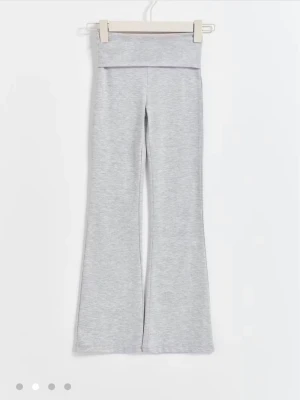 Grå yogapants - Snygga ljusgrå yogpants med bootcut-ben och hög midja. Perfekta för chill dagar och har en mjuk och stretchig känsla. Passformen är loose och materialet är bomullsmix som känns skönt mot huden.