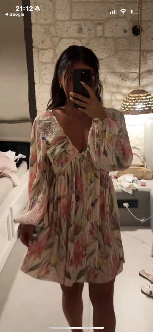 Blommig kortklänning  - Säljer denna populära Blommig långärmad kort klänning från H&M🩷använd fåtal gånger, skriv om ni är frågor 