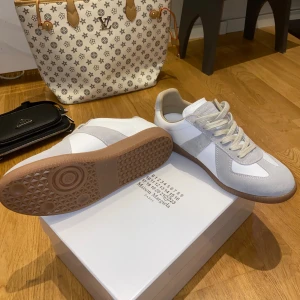 MM22 gats vit/grå - ! PRIS GÅR ATT DISKUTERAS VID SNABB AFFÄR !MM22 sneakers i vitt och ljusgrått med klassisk retrodesign. Ovandel i lammnappa och kalvskinn med mockadetaljer, beige snörning och gummisula. Perfekta för dig som gillar minimalistisk och stilren look.