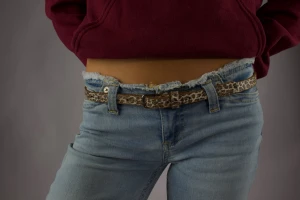 Leopardmönstrat brunt skärp - Säljer ett smalt bälte med leopardmönster i bruna och beige toner. Bältet har en klassisk form med metallspänne och passar perfekt till jeans eller kjol för att ge outfiten en cool touch.