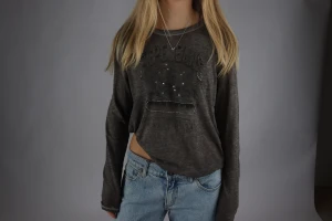 Mörkgrå långärmad tröja Pepe Jeans - Säljer en mörkgrå långärmad tröja från Pepe Jeans med coolt tryck och små diamanter framtill. Tröjan har en loose passform och är perfekt att matcha med jeans. Materialet känns mjukt och skönt mot huden. Denna tröja är unik och ett måste för garderoben 