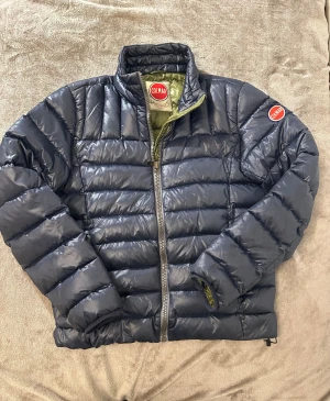 Colmar jacka  - Snygg och varm glansig marinblå Colmar jacka. 10/10 skick om man inte räknar med en liten 🤏defekt (se bild 6) Storlek S . Skickar innom 24 timmar🚀.