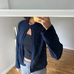 Mörkblå kofta från Gina Tricot - Mysig mörkblå kofta från Gina Tricot i stickat material. Koftan har rund halsringning, lång ärm och stängs med en knapp upptill. Perfekt att slänga över en topp för en chill look.