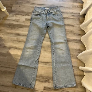 Ljusblå bootcut jeans med fickdetaljer - Säljer ett par ljusblå jeans med bootcut-modell och snygga fickdetaljer bak. Jeansen har klassisk femficksdesign, bälteshällor och dragkedjegylf. Perfekta för dig som gillar en retro vibe och vill ha ett par jeans med lite vidare ben.