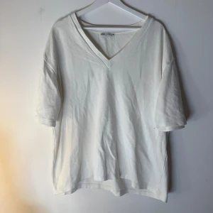 Zara tröja  - Vit t-shirt med V-ringning och korta ärmar. Enkel och stilren design. Storlek M men lite oversize o tjock i materialet 