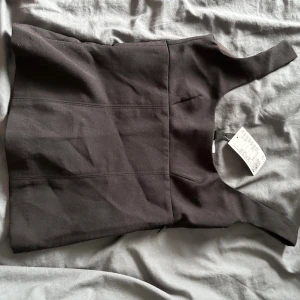 Svart fest topp - Säljer denna toppen då den var för liten redan när jag köpte den. Prislapp är kvar och aldrig använt. Finns en dragkedja på sidan som man kan göra vad man vill med.