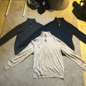 Tre polotröjor med half zip - Säljer tre halv-zip tröjor i olika färger: mörkgrå, marinblå och beige. Alla har långärmad design och ribbade muddar vid ärmslut och nederkant. Inga skador eller vidare och användning märks knappast, säljer tröjorna för 125kr/st
