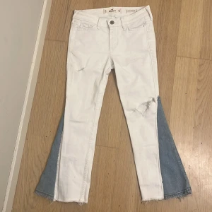 Vita jeans med blå bootcut - Säljer dessa DÖÖÖ snygga jeans (enligt mig) eftersom att de är för korta för mig! Har sytt till bootcut och lagt till hål själv men annars är det skinny jeans från hollister! Skriv vid frågor eller mått på jeansen💌 aldrig används bara testats (från mig iaf vet inte skicket från sellpy)🩷