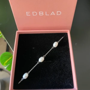 Silverarmband med pärlor från Edblad - Fint armband från Edblad med tunn silverkedja och vita pärlor. Har inte använt detta så mycket och säljer de på grund av att jag vill byta ut mina smycken till guld! 