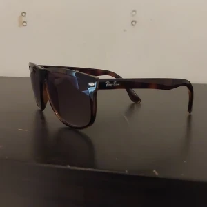 Ray-Ban boyfriend solglasögon  - Snygga Ray-Ban solglasögon med brunmelerad båge och mörka glas. Modellen har en klassisk, fyrkantig form och diskret Ray-Ban-logga på skalmen. Perfekta för dig som vill ha en grisch och clean look.(pris kan diskuteras vid snabb affär)