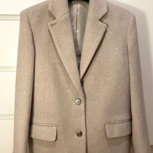 Oversized ull kappa - Wool Coat. Only worn one time for picture. Size is 32 but is oversized. Material is wool blend. Bought for 2000kr.