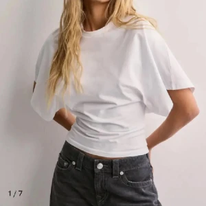 Vit topp - Vit snygg topp med tajt midja och lösare upp till från Nelly i storlek S, endast använd 1-2 ggr