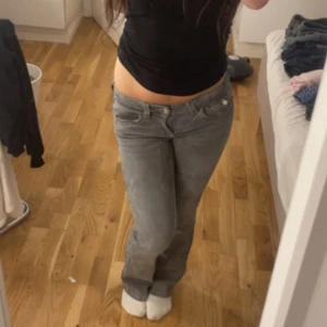 Grå bootcut jeans med fickdetaljer - Säljer ett par grå jeans med bootcut-modell och låg midja. Jeansen har fickor. Storlek 152. Köpt i Gina young. 