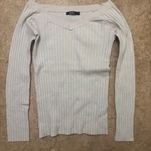 Ljusribbad v-ringad tröja Gina Tricot - Säljer en ljus, ribbad tröja från Gina Tricot med v-ringad hals och lång ärm. 