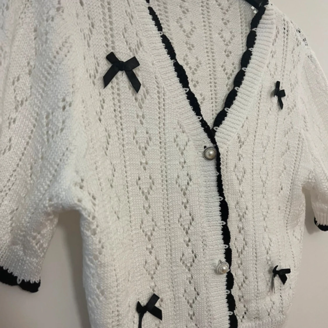 Vit stickad kofta med svarta rosetter - 2