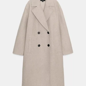 Beige oversized ullkappa från Zara - Snygg oversized kappa i beige ullmix från Zara. Dubbelknäppt med svarta knappar, breda slag och raka fickor framtill. Lång modell med detaljer vid ärmslutet. Perfekt för dig som gillar en clean och stilren look. Nypris 859💕