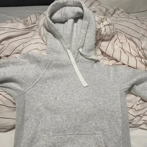 Ljusgrå hoodie med snörning - Säljer en russemerch hoodie! Den är i bra skick andvänt kanske 5-6 gånger, lite för liten för mig! Hör av dig vid frågor!