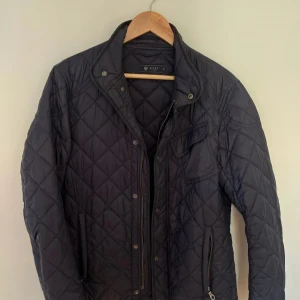 Mörkblå quiltad jacka från Riley - Snygg mörkblå quiltad jacka från Riley perfekt för hösten. Funkar även för kyligare väder med tjocktröja undertill. 