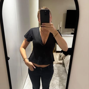 Svart topp med v-ringning - Supersnygg populär svart topp från Gina tricot, säljer då den ej kommer till användning. Använd fåtal gånger och därmed inga defekter.💗