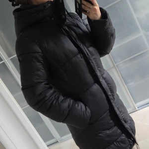 Vinterjacka från hm - Svart lite glansig vinterjacka i storlek xs från H&M i fint skick.Längd fram 87cm & bak 94cm.Dragkedjan går att öppna både nertill och upptill.💕