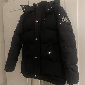 Moose knuckles  - Säljer en svart pufferjacka från Moose Knuckles. Nu när de kyliga dagarna väntar oss så är den bästa investeringen för dig att satsa på en jacka som håller dig varm och stilig. Jackan är storlek XL för barn alltså passar den allt från 168-173 cm.  Säljer då den tyvärr inte längre passar mig. Hör gärna av dig vid några frågor.