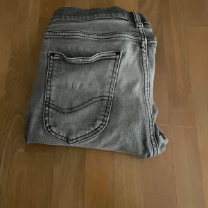 Grå jeans från Lee - Snygga grå jeans från Lee, mycket sparsamt använd i min ägo. Jag säljer dessa då det är för små. Hör av er vid yttligare frågor😇 Ett hål se bild.