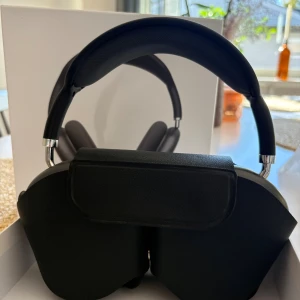 AirPods Max - Snygga Apple AirPods Max i Space Gray, over-ear trådlösa hörlurar med aktiv brusreducering. Komplett med originalförpackning och skyddsfodral. Hörlurarna ser ut att vara i mycket gott skick utan synligt slitage eller repor. Perfekt för musik, film och samtal.