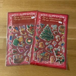 Pop-up klistermärken - Två ark med pop-up klistermärken med julmotiv! Perfekt för att dekorera anteckningsböcker, julkort eller presenter. Motiven inkluderar julgran, tomte, nalle, presenter och godis. Roliga och färgglada stickers som passar både ungdomar och unga vuxna.