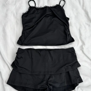 Svart set - Svart med svart cami-topp och shorts, stretchigt tyg, i storlek L. Aldrig använda. Fraktar inom 24h!