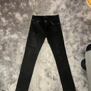 Nudie Jeans - Säljer dessa tvärsnygga jeans från Nudie med klassisk femficksdesign och snygga kontrastsömmar på bakfickorna. Modellen är Lean Dean med smal passform och låg midja stl W32 L34. Jeansen är tillverkade i stretchig bomull för extra komfort och har silverfärgade nitar och knapp. 