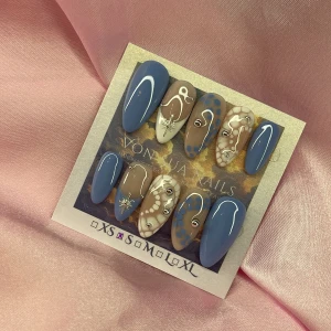 Snowfall (S);Medium Almond - Snygga handgjorda press-on naglar i blått, nude och vitt med coola abstrakta mönster, prickar och silvriga detaljer. Långa, mandelformade naglar med glansiga ytor samt små stjärnor och pärlor för extra detalj. S: 15 mm, 11,5 mm, 12 mm, 11 mm, 9 mm 